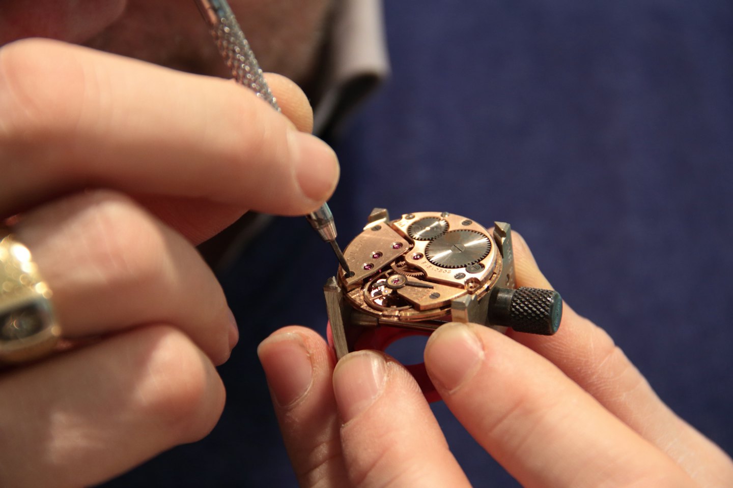 Un orologiaio usa uno strumento di precisione per riparare gli ingranaggi di un orologio meccanico.